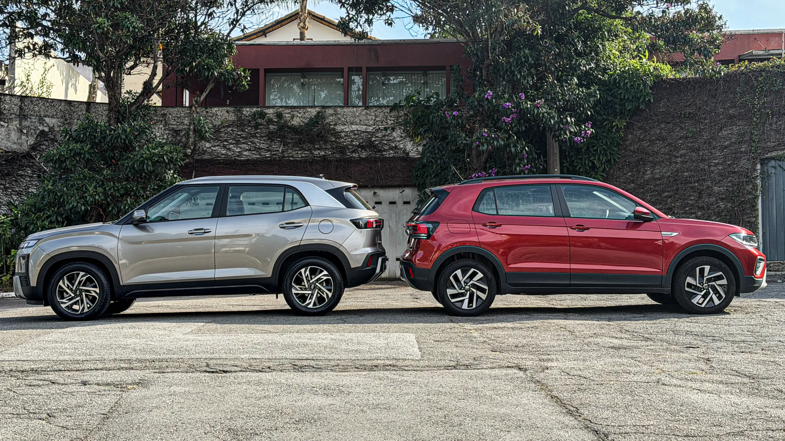 Volkswagen T-Cross Comfortiline Vermelho Sunset ao lado do Hyundai Creta Limited (na cor Cinza Silk estático