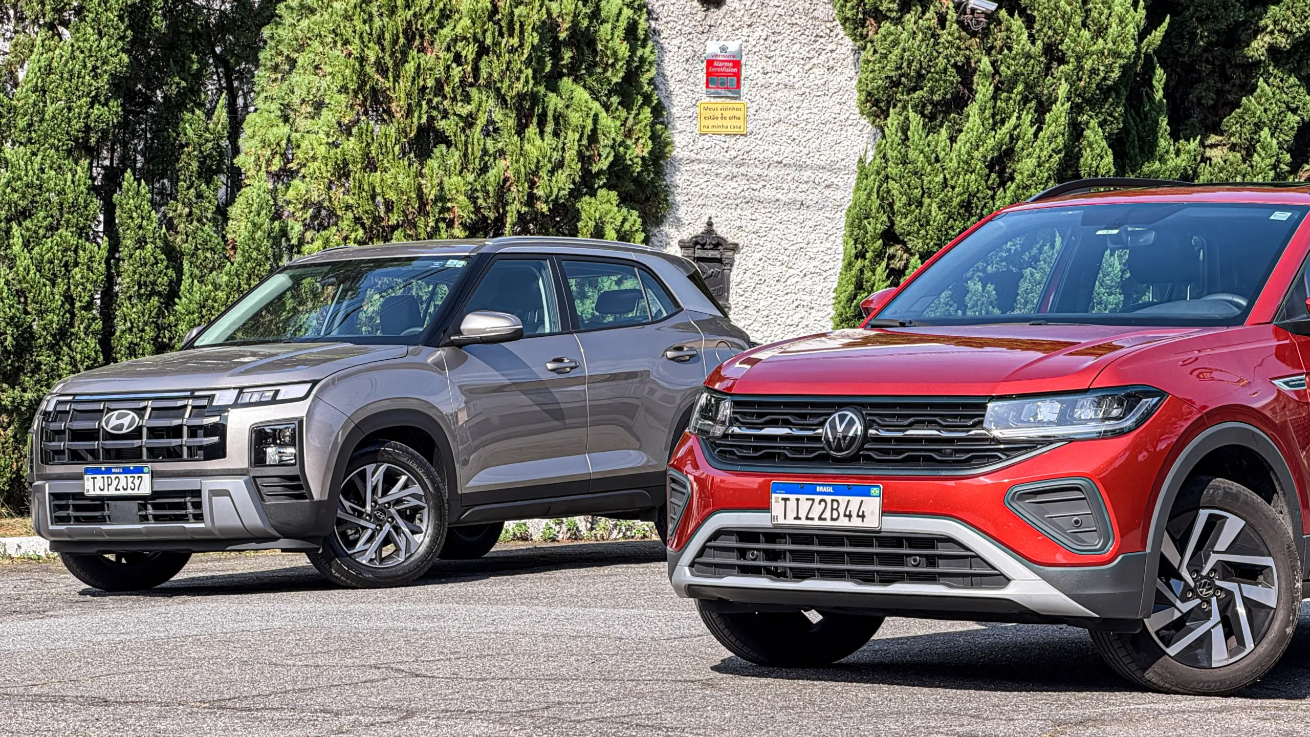 Volkswagen T-Cross Comfortiline Vermelho Sunset ao lado do Hyundai Creta Limited (na cor Cinza Silk estático