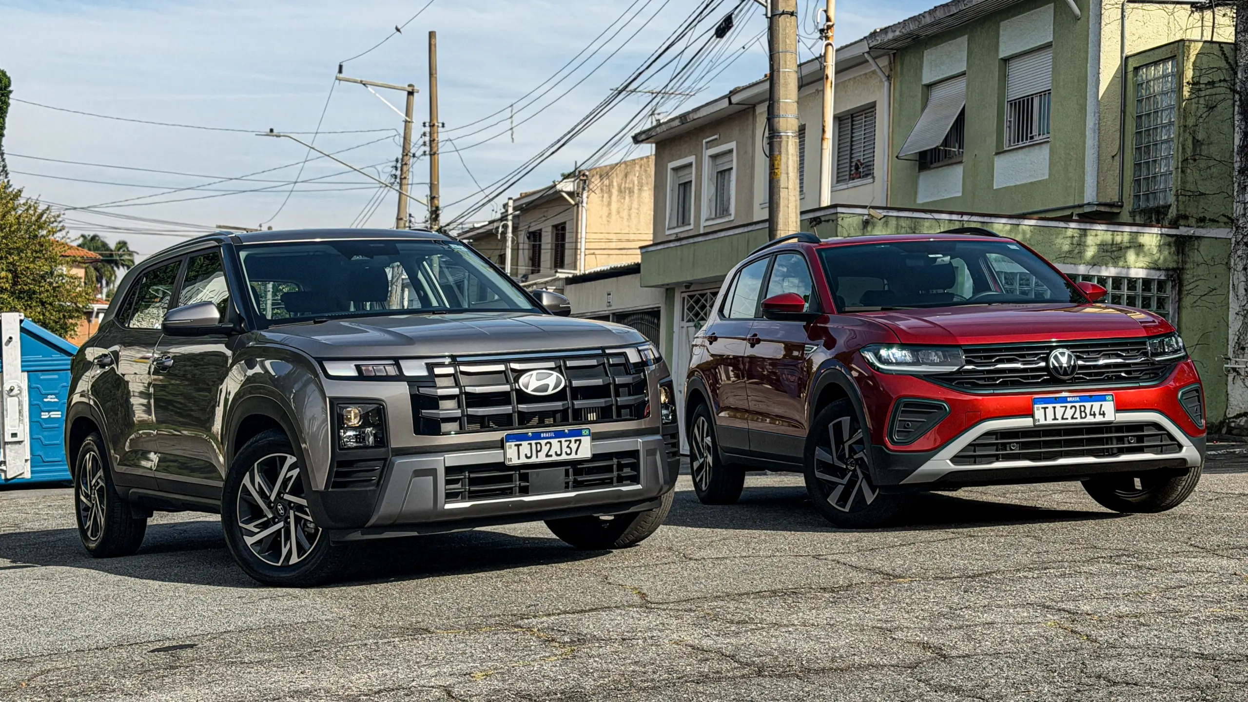Volkswagen T-Cross Comfortiline Vermelho Sunset ao lado do Hyundai Creta Limited (na cor Cinza Silk estático