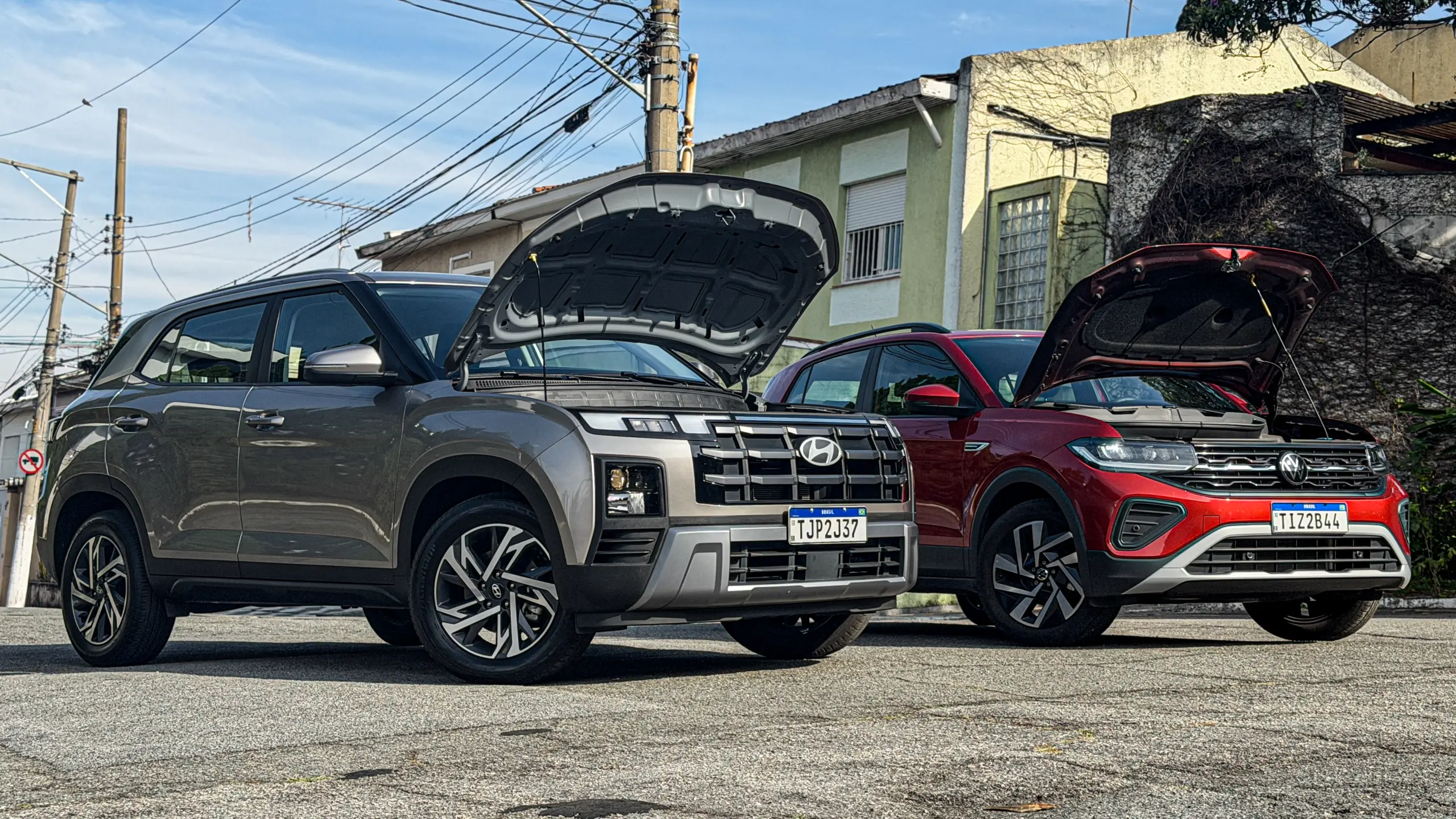 Volkswagen T-Cross Comfortiline Vermelho Sunset ao lado do Hyundai Creta Limited (na cor Cinza Silk estático