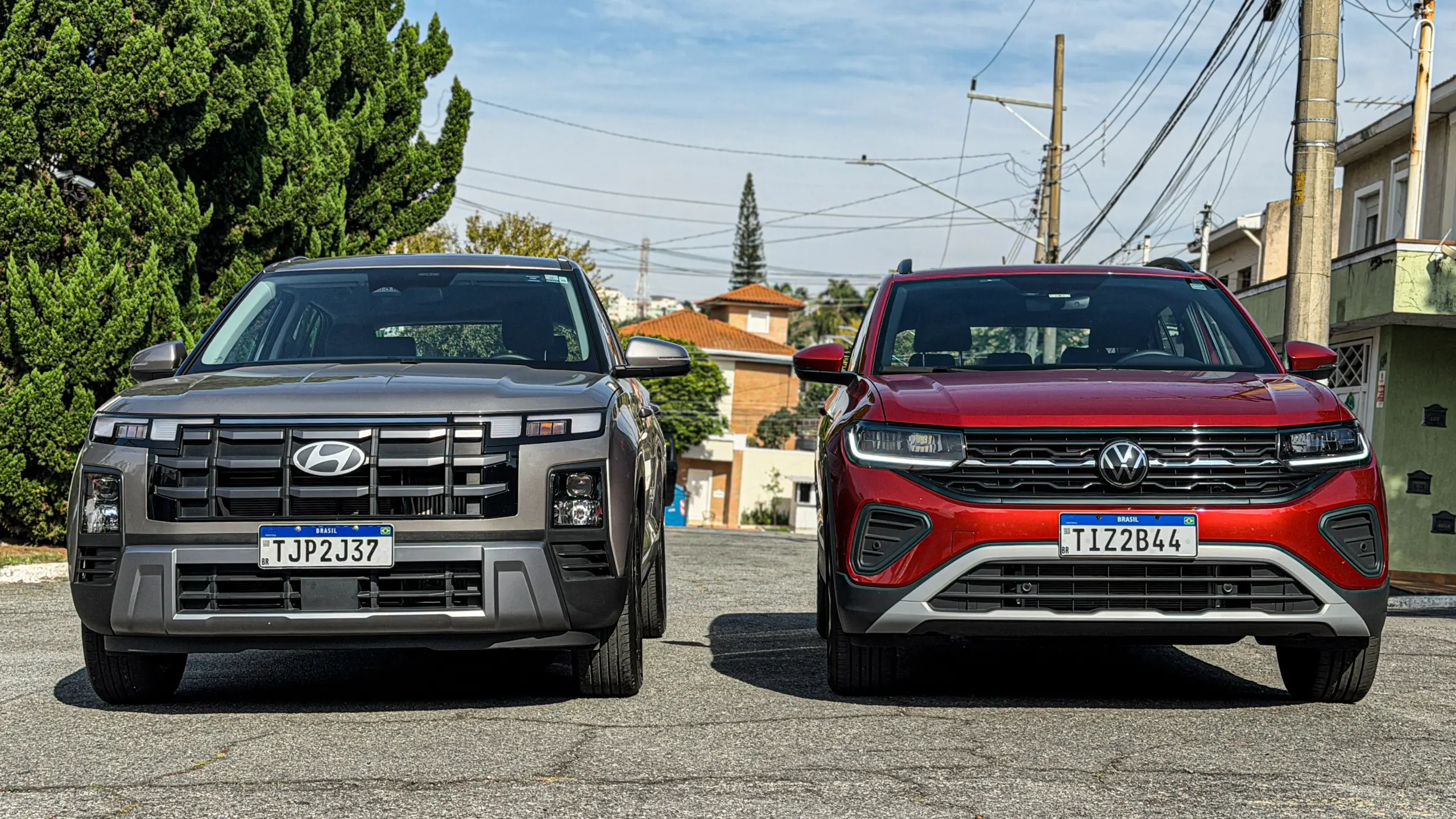 Volkswagen T-Cross Comfortiline Vermelho Sunset ao lado do Hyundai Creta Limited (na cor Cinza Silk estático