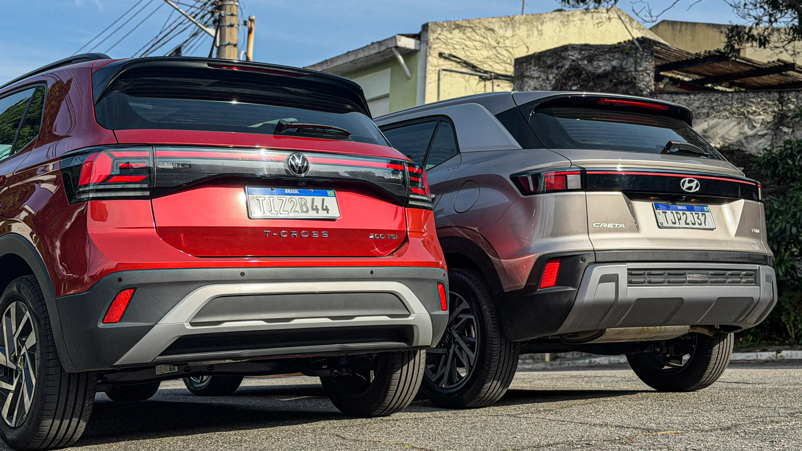 Volkswagen T-Cross Comfortiline Vermelho Sunset ao lado do Hyundai Creta Limited (na cor Cinza Silk estático
