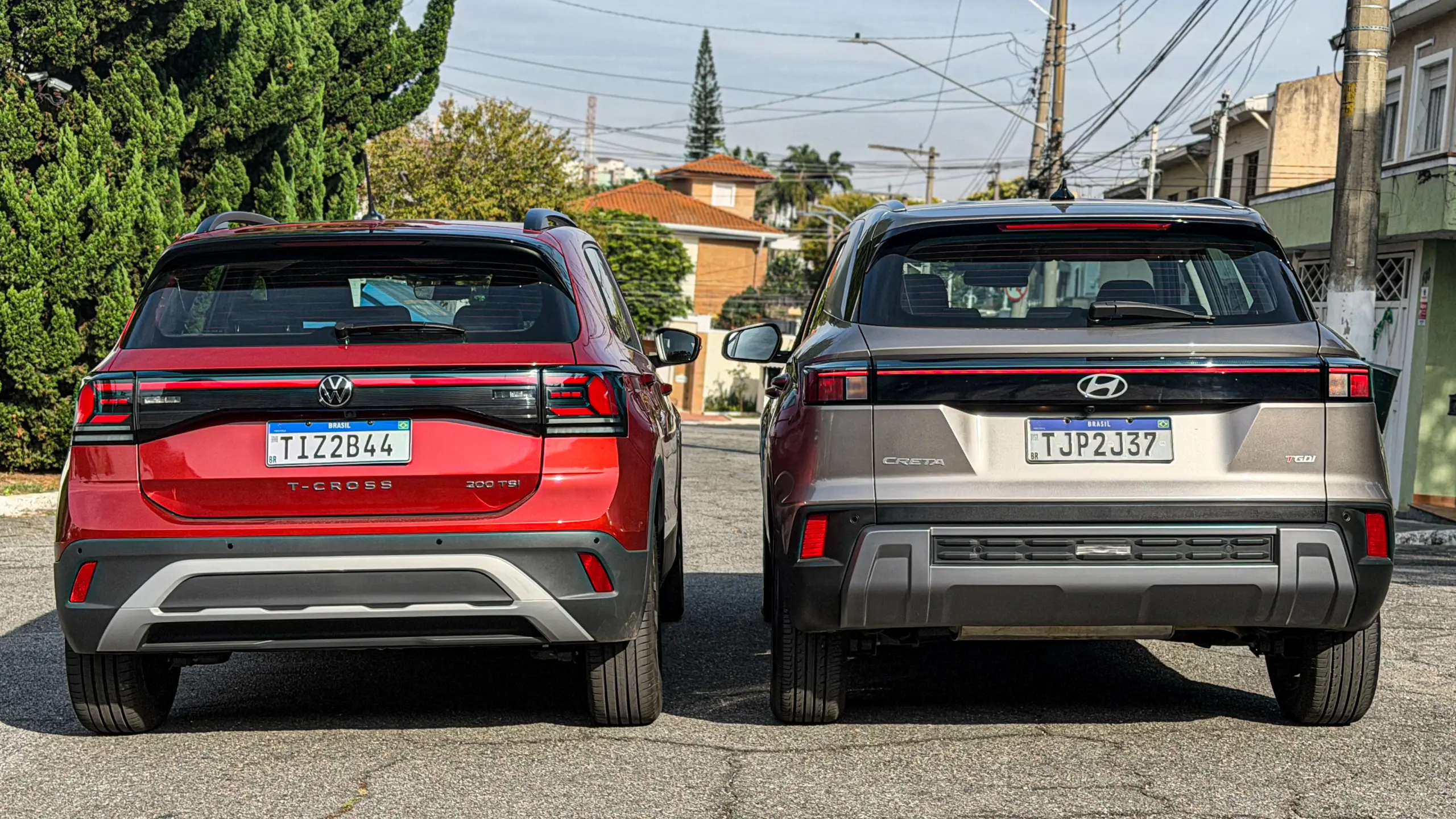 Volkswagen T-Cross Comfortiline Vermelho Sunset ao lado do Hyundai Creta Limited (na cor Cinza Silk estático