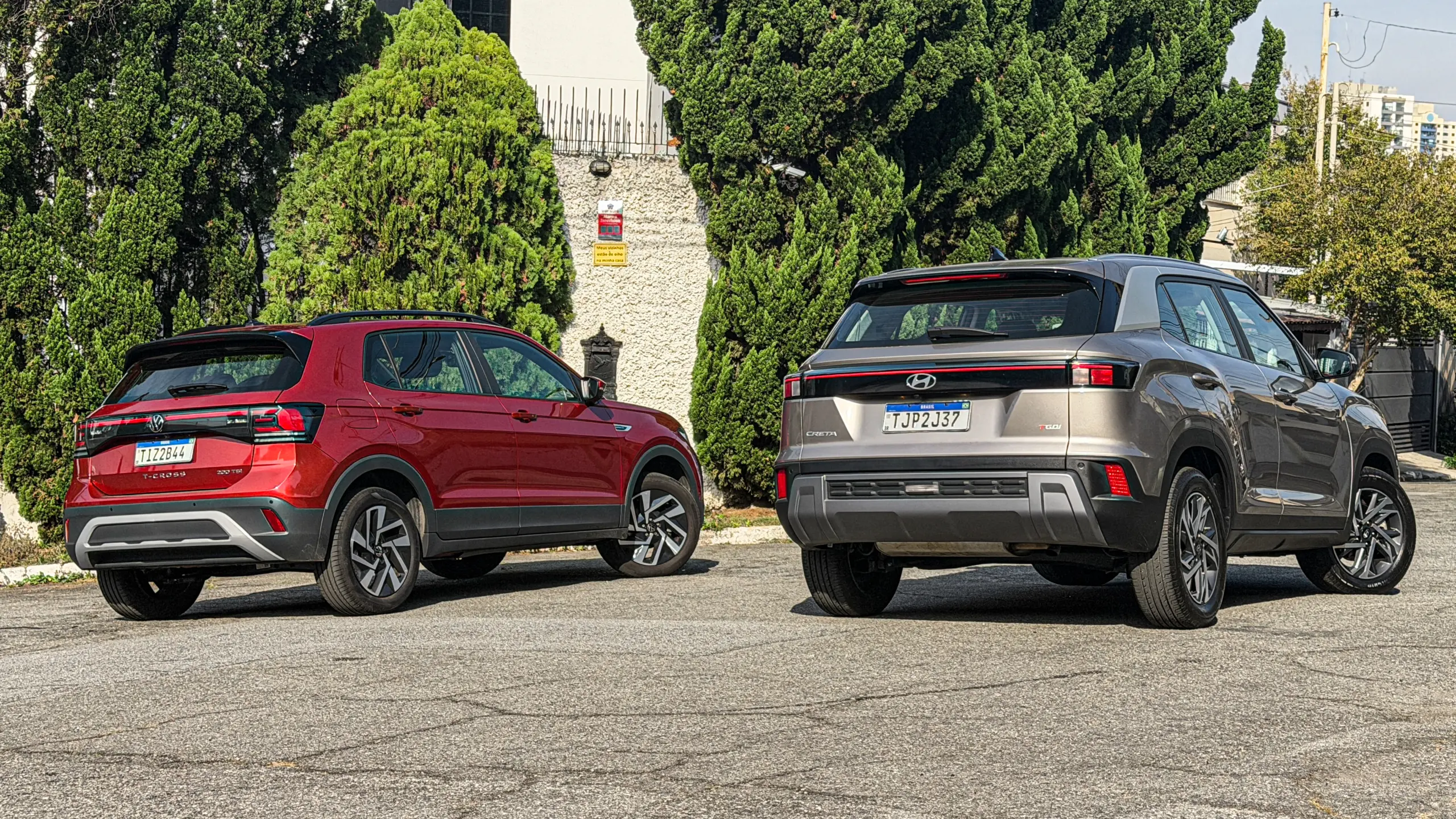 Volkswagen T-Cross Comfortiline Vermelho Sunset ao lado do Hyundai Creta Limited (na cor Cinza Silk estático