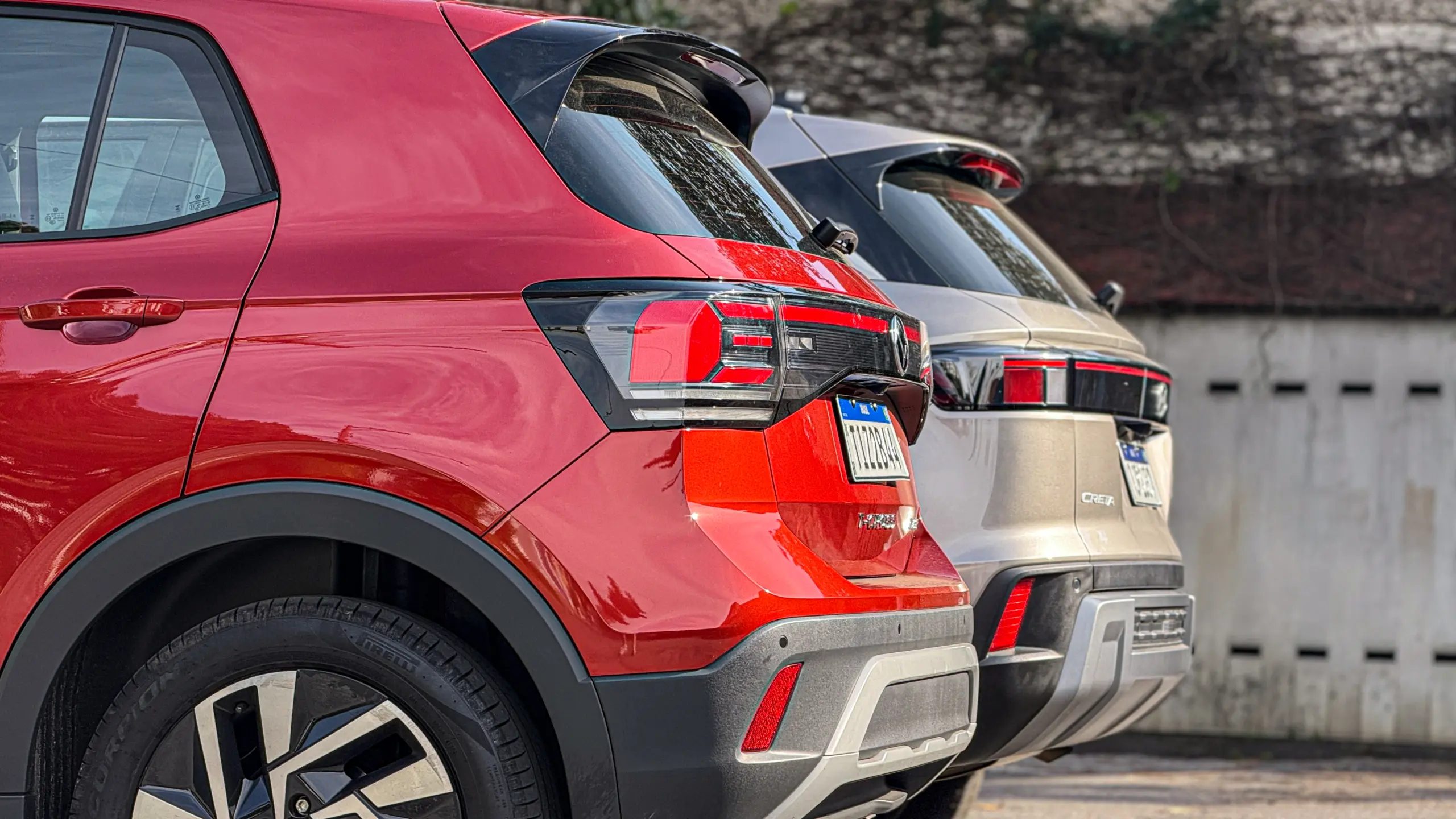 Volkswagen T-Cross Comfortiline Vermelho Sunset ao lado do Hyundai Creta Limited (na cor Cinza Silk estático