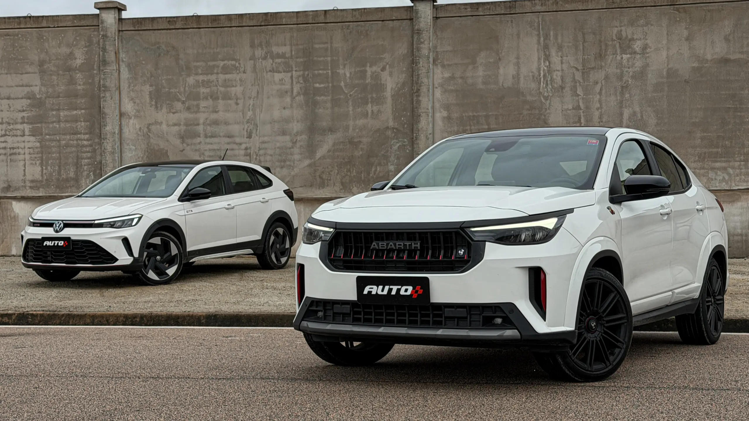 Fiat Fastback Abarth e Volkswagen Nivus GTS brancos estáticos um do lado do outro para comparativo de avaliação e teste