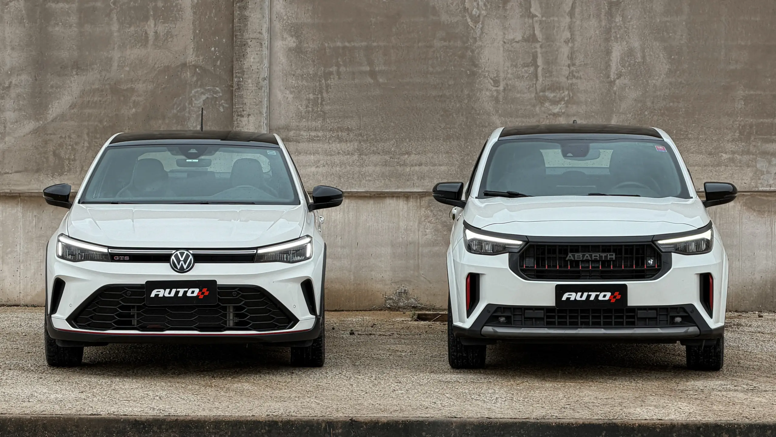 Fiat Fastback Abarth e Volkswagen Nivus GTS brancos estáticos um do lado do outro para comparativo de avaliação e teste