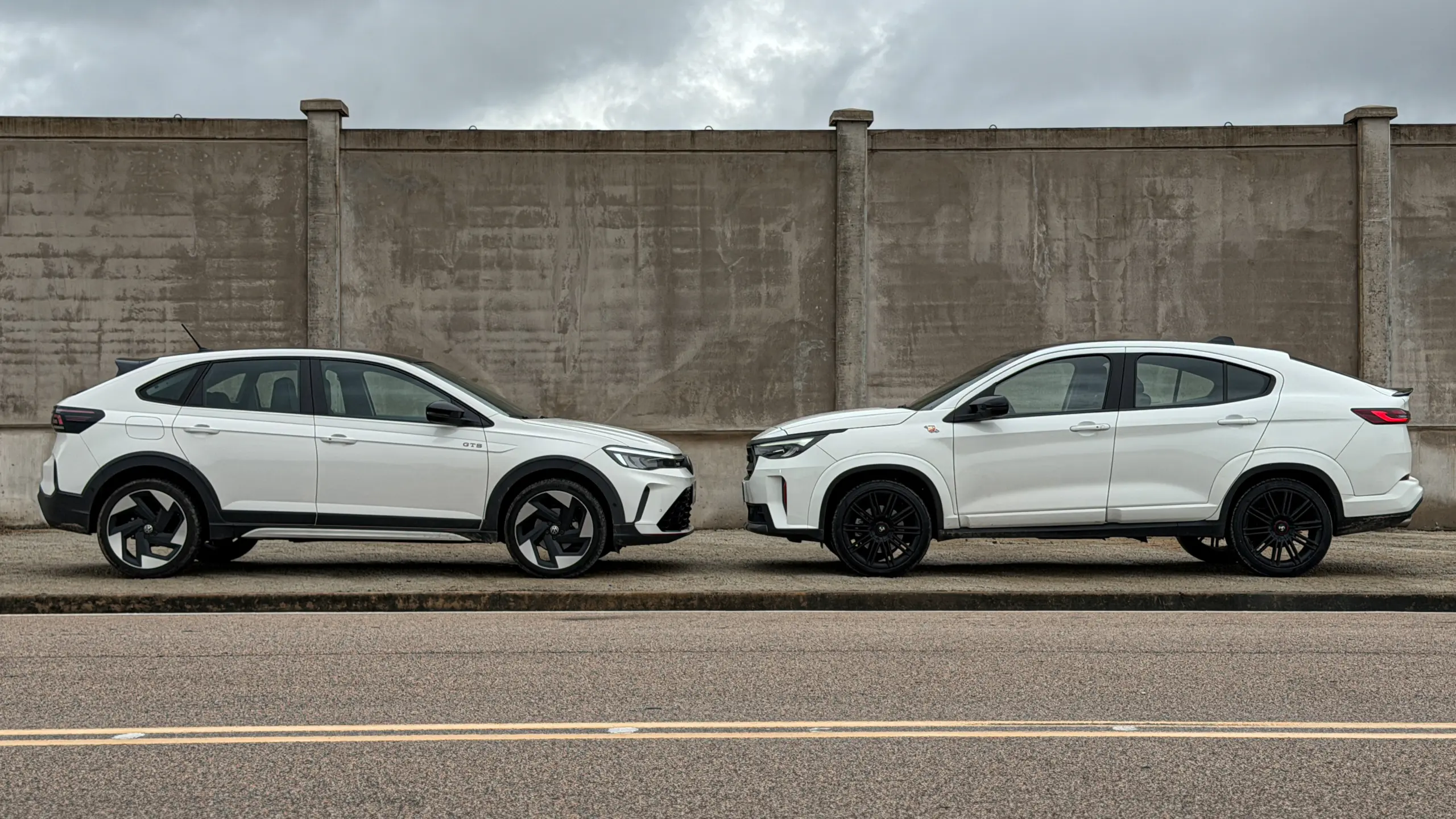 Fiat Fastback Abarth e Volkswagen Nivus GTS brancos estáticos um do lado do outro para comparativo de avaliação e teste
