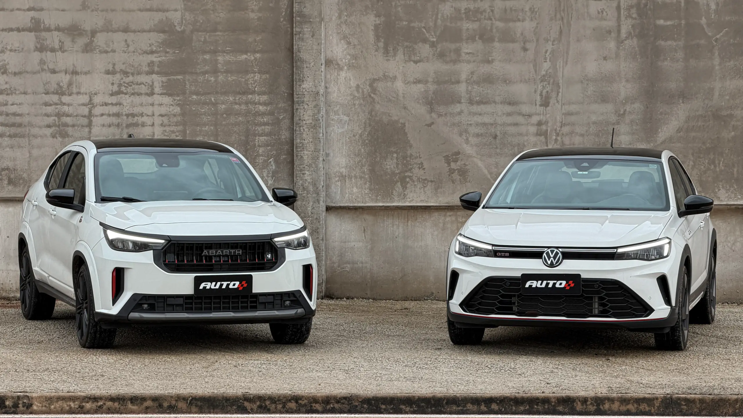 Fiat Fastback Abarth e Volkswagen Nivus GTS brancos estáticos um do lado do outro para comparativo de avaliação e teste