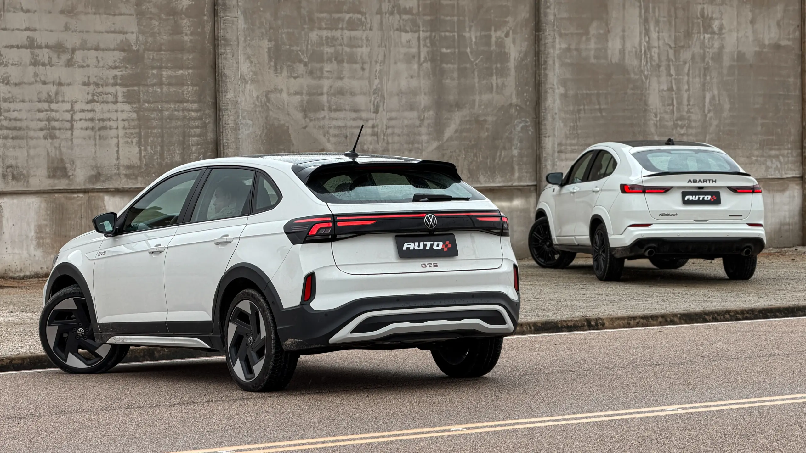 Fiat Fastback Abarth e Volkswagen Nivus GTS brancos estáticos um do lado do outro para comparativo de avaliação e teste