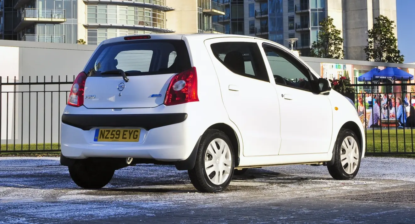 Antigo Nissan Pixo branco parado de traseira