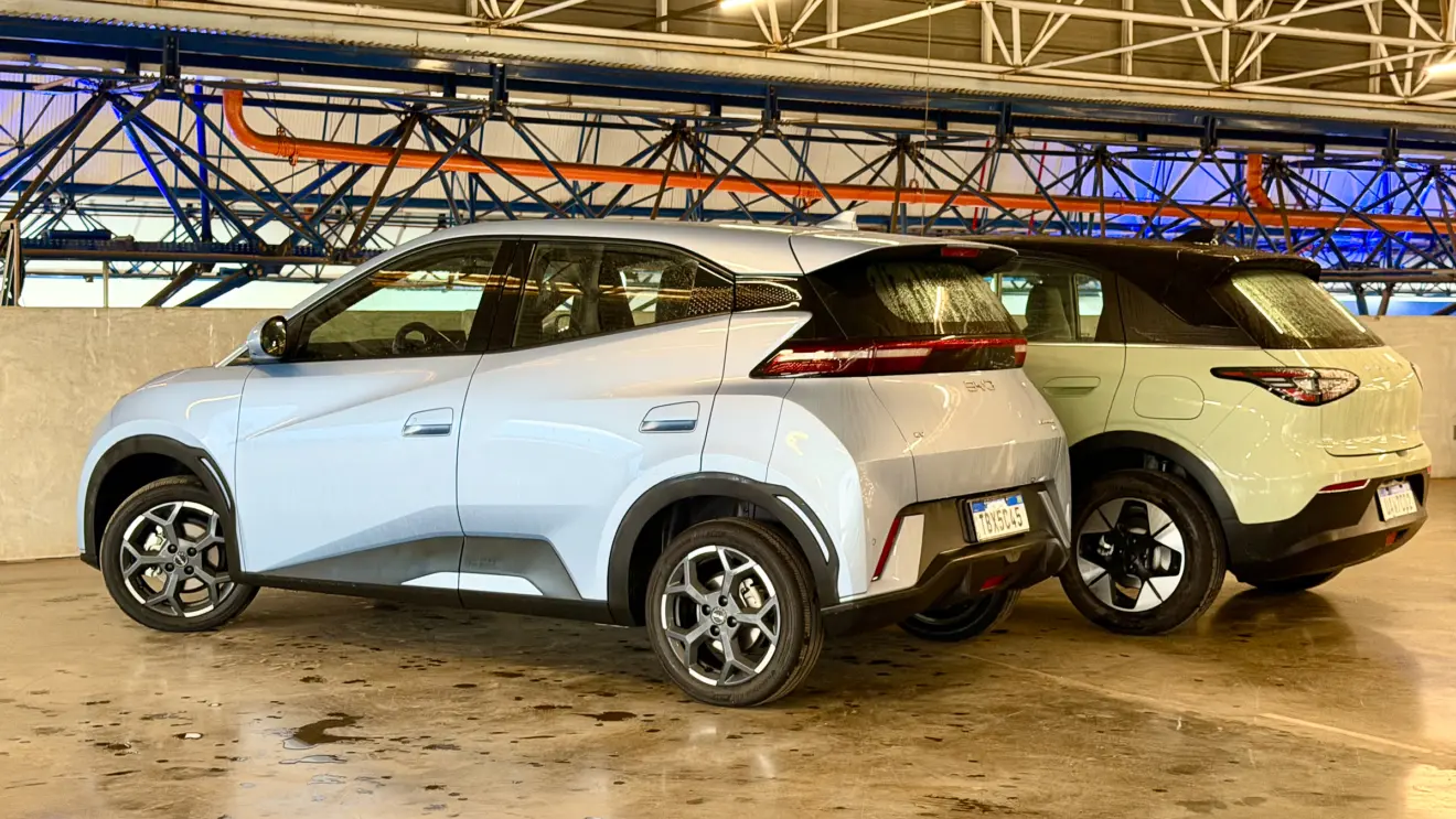 Geely EX2 verde de frente vs BYD Dolphin Mini azul de traseira com um fundo azul forte
