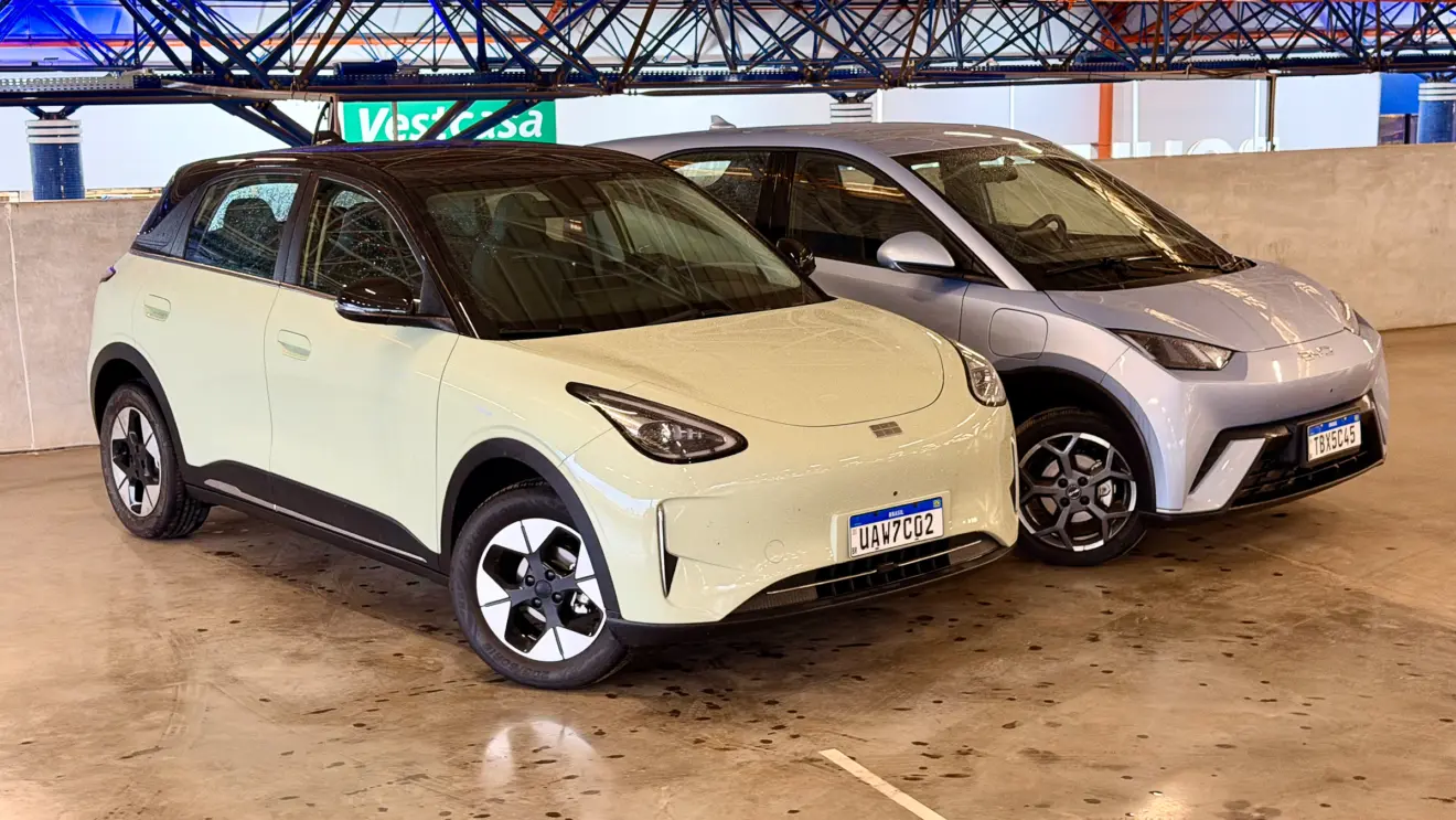 Geely EX2 verde de frente vs BYD Dolphin Mini azul de frente com um fundo azul forte