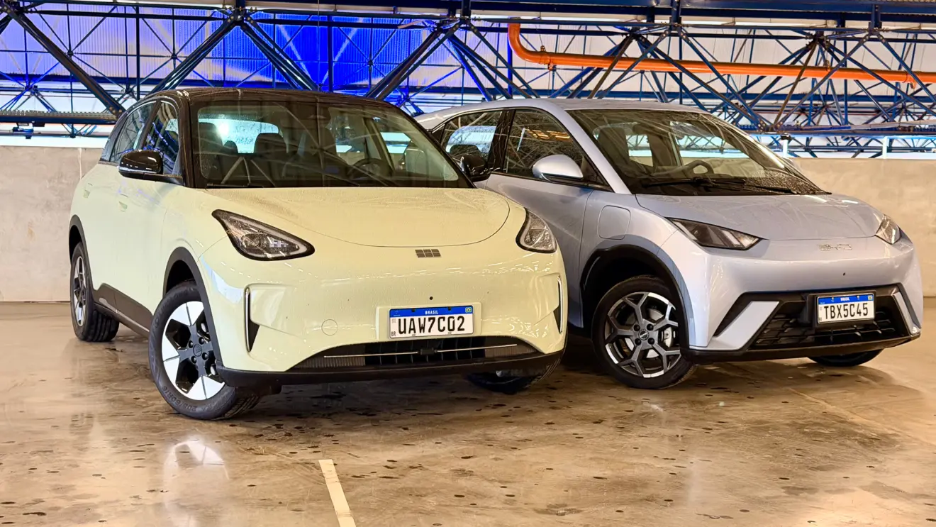 Geely EX2 verde de frente vs BYD Dolphin Mini azul de frente com um fundo azul forte