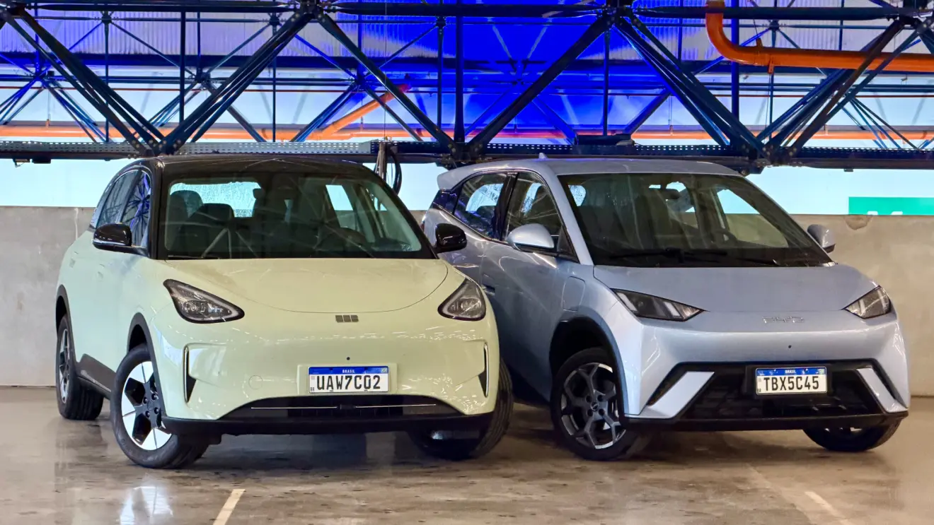 Geely EX2 verde de frente vs BYD Dolphin Mini azul de frente com um fundo azul forte