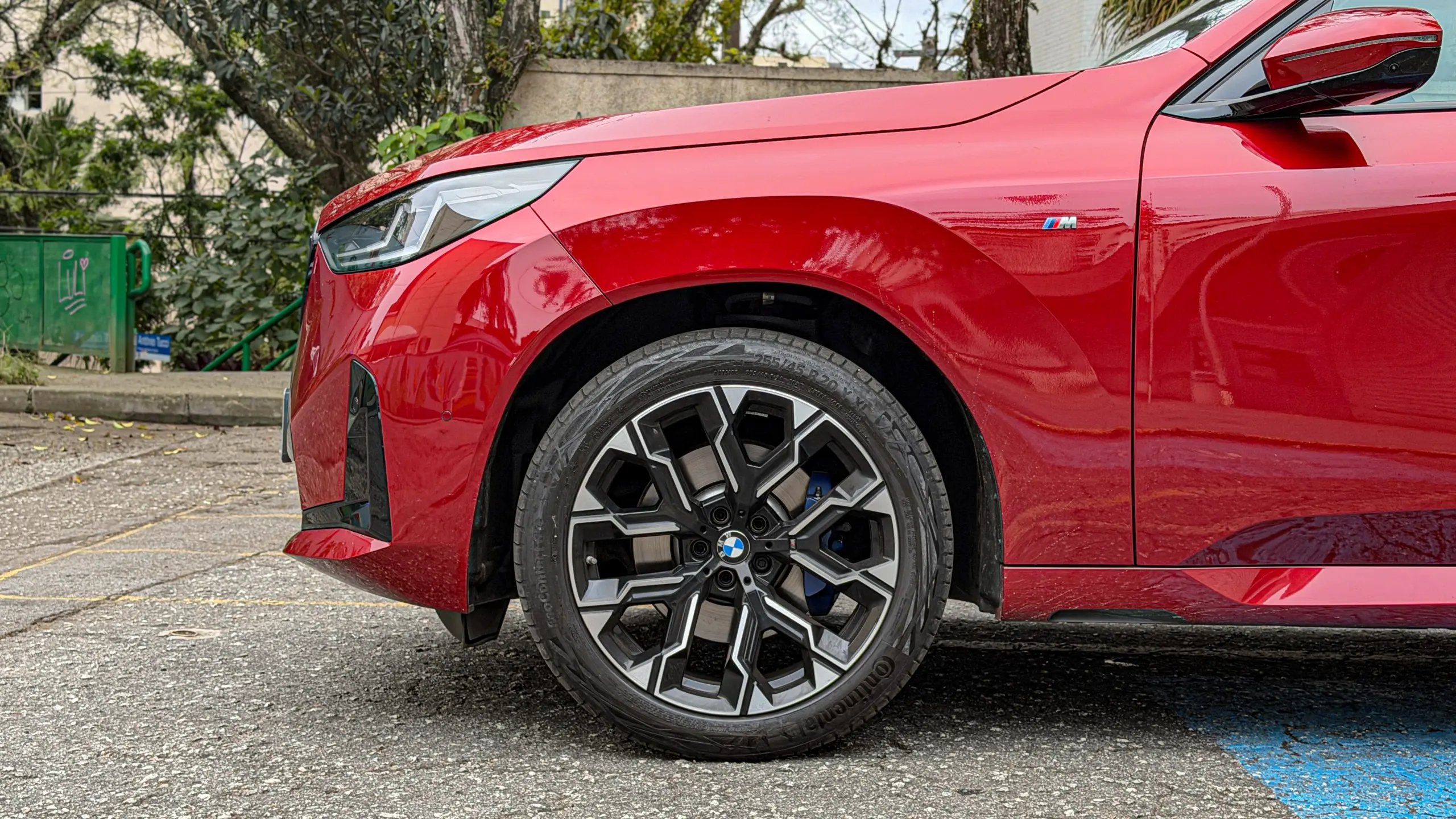 Detalhes do BMW X3 estático na cor Vermelho Fire no asfalto para teste e avaliação