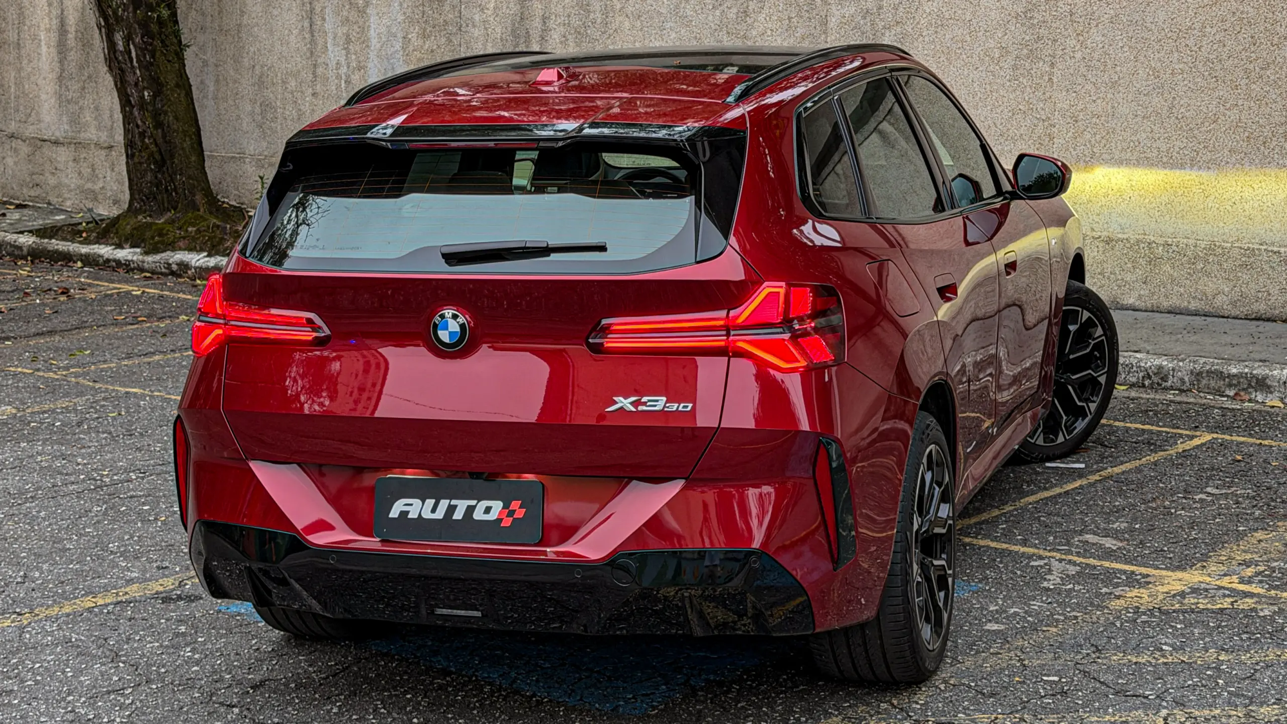 BMW X3 estático na cor Vermelho Fire no asfalto para teste e avaliação