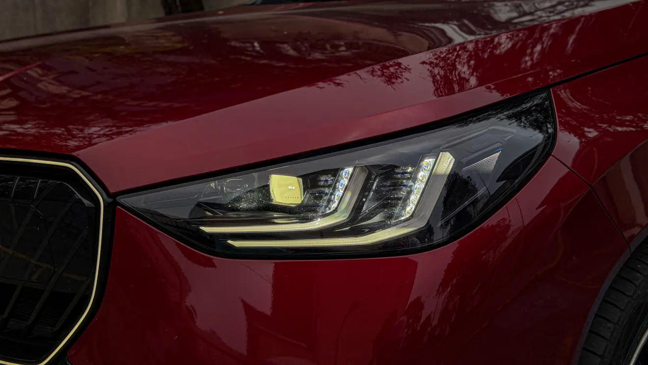 Detalhes do BMW X3 estático na cor Vermelho Fire no asfalto para teste e avaliação