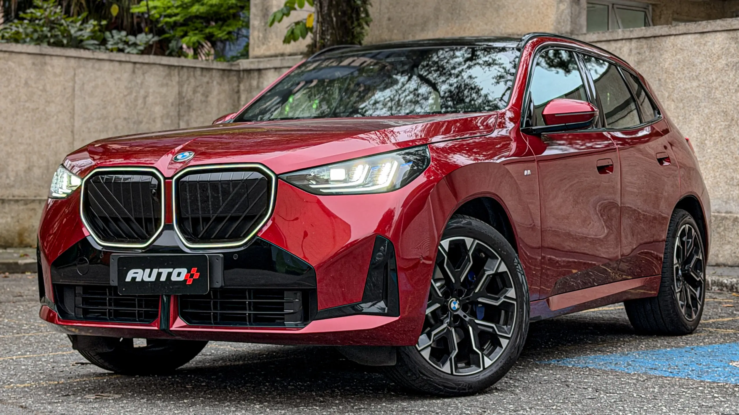 BMW X3 estático na cor Vermelho Fire no asfalto para teste e avaliação