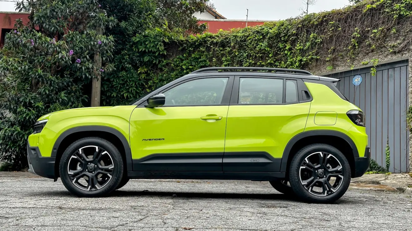 Jeep Avenger Limited parado de lateral com muro de cimento e plantas ao fundo