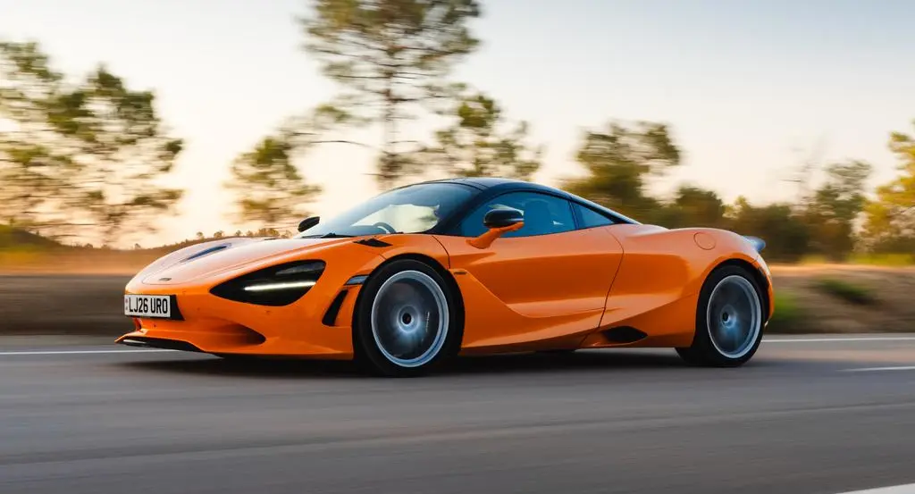 McLaren 750S laranja em movimento de lateral na estrada
