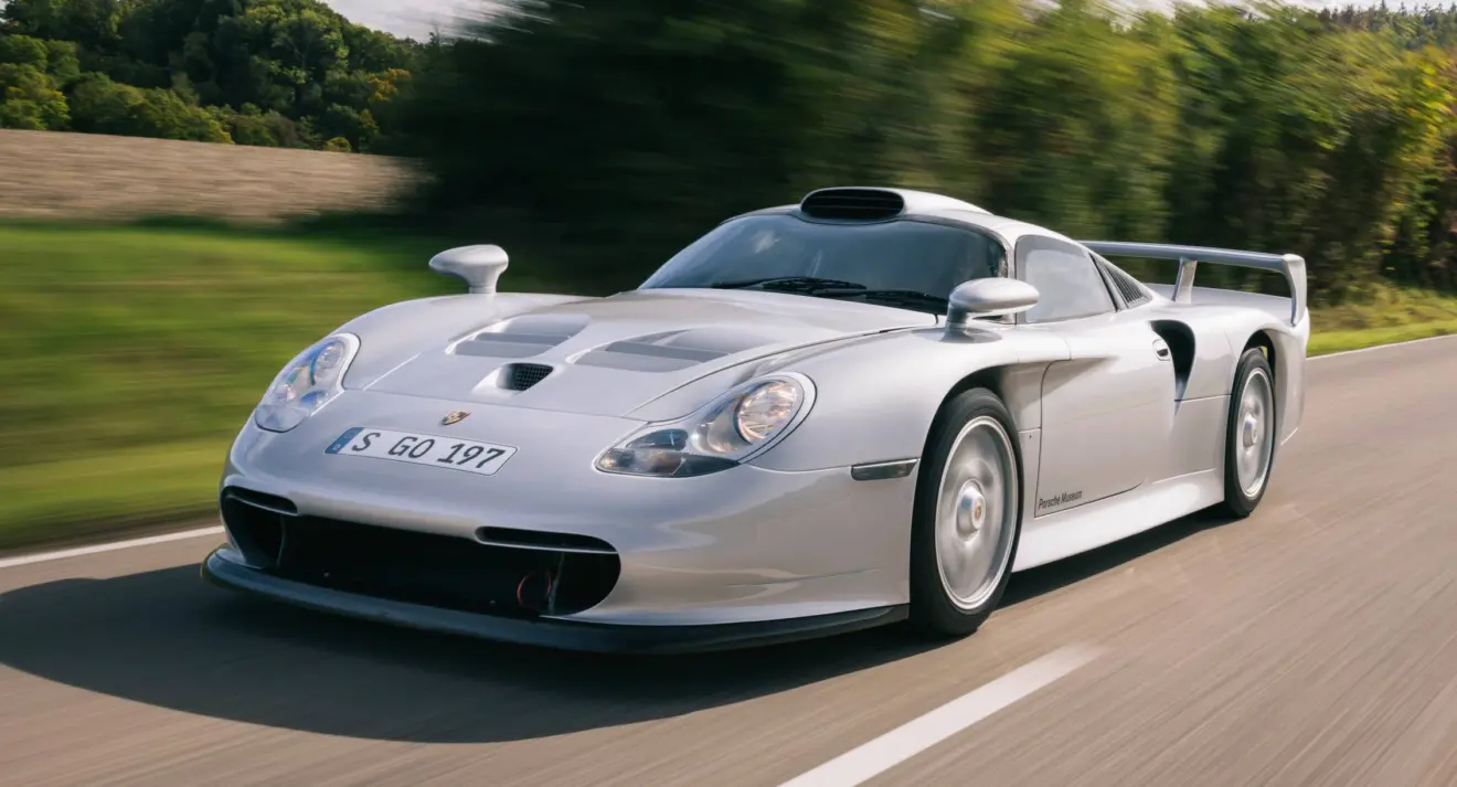 Porsche 911 GT1 prata de dianteira em movimento na estrada