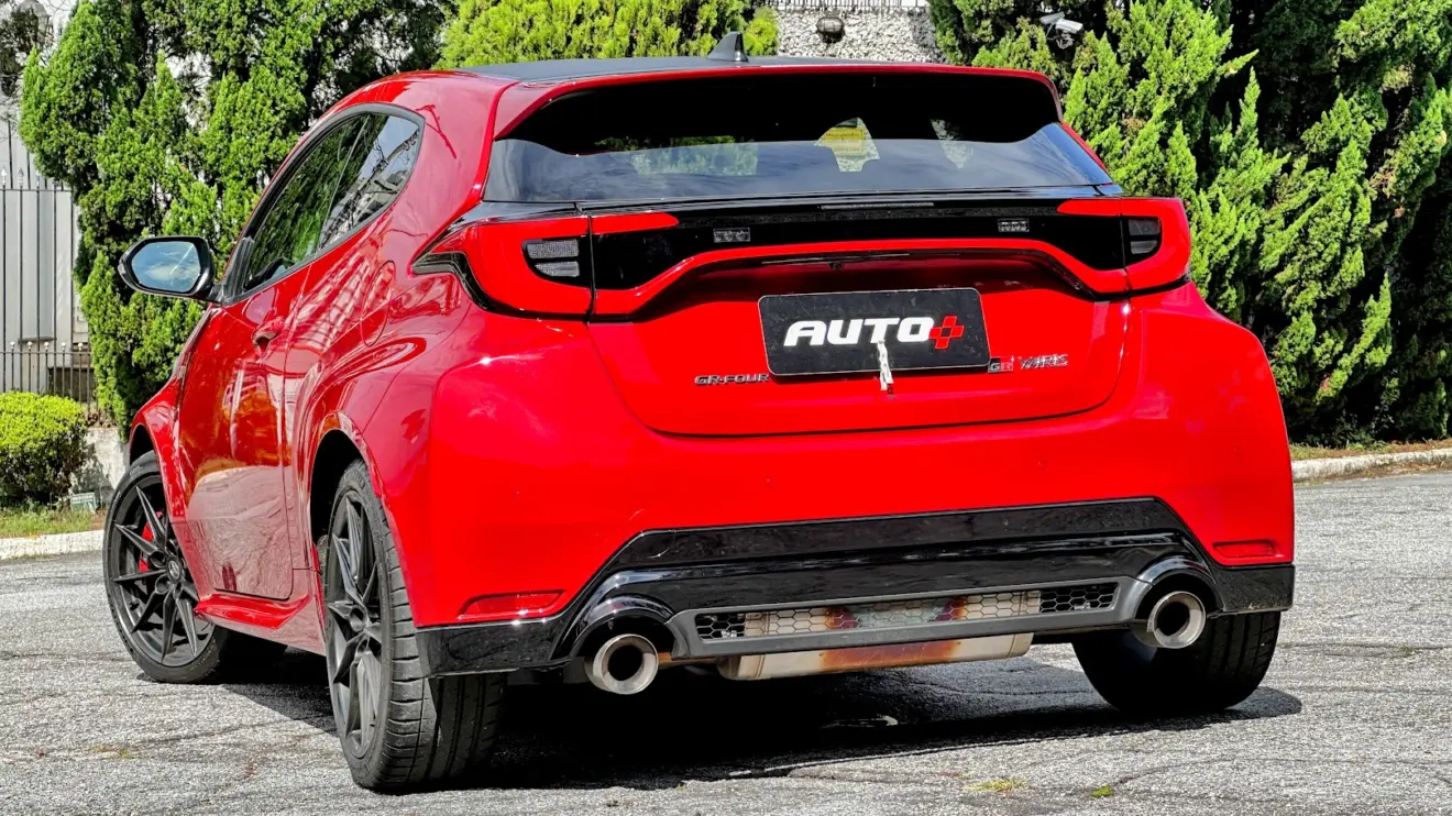 Toyota GR Yaris manual vermelho parado de traseira com casa ao fundo